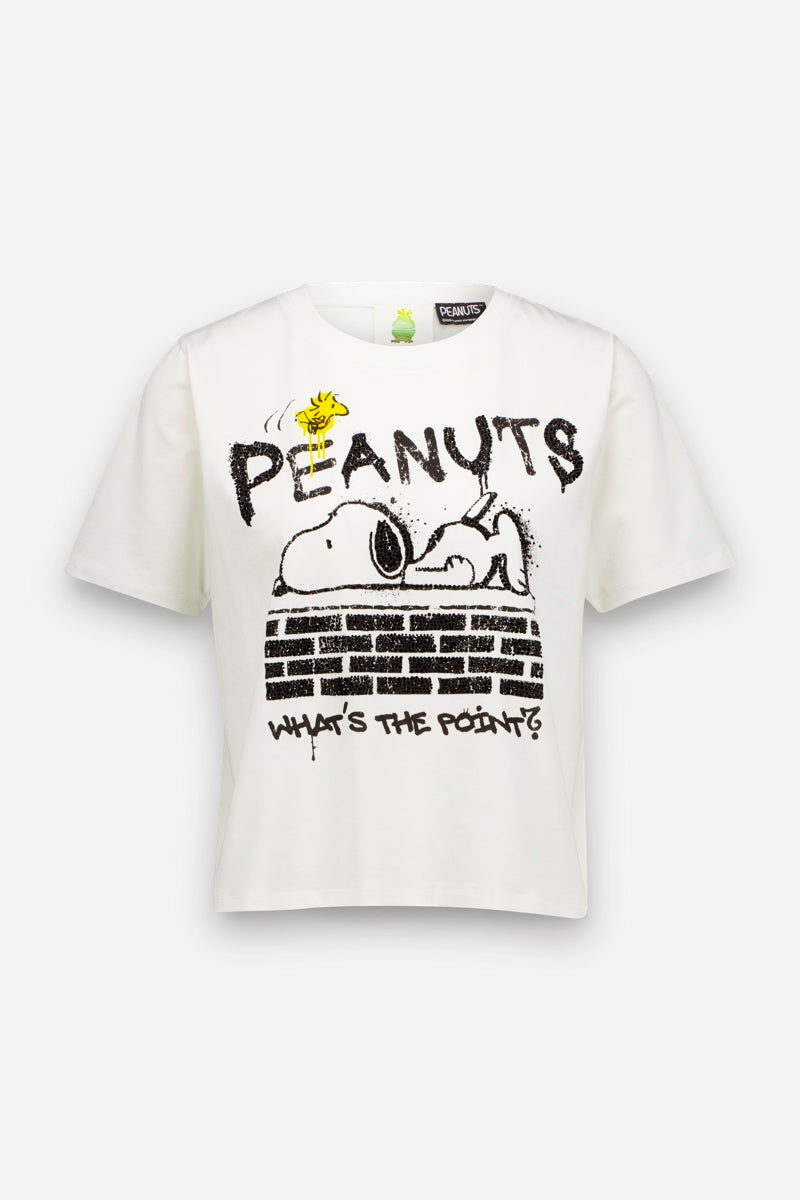 Ein weißes „Peanuts“-T-Shirt aus 100 % Baumwolle, auf dem Snoopy auf seiner Hundehütte liegt und Woodstock über ihm zu sehen ist. Das Motiv enthält die Schriftzüge „PEANUTS“ und „WHATS THE POINT?“ in einer abgenutzten, schwarzen Schriftart.