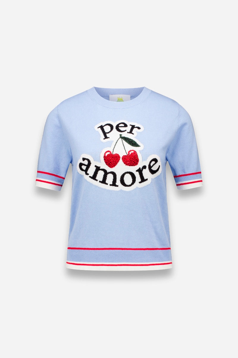 Der pastellblaue Princess Goes Hollywood Per Amore Pullover zeigt den Schriftzug "per amore" in fetter schwarzer Schrift mit zwei roten Kirschen zwischen den Wörtern sowie rot-weiß gestreifte Borten an den Ärmeln und am Saum vor einem schlichten hellen Hintergrund.