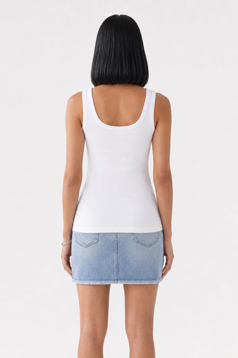 Eine Frau mit glattem schwarzem Haar, von hinten gesehen, trägt ein weißes Basic-Top mit Rundhalsausschnitt aus Baumwolle von „Princess Goes Hollywood“ und einen hellblauen Jeans-Minirock. Ihre Arme liegen an den Seiten, und der Hintergrund ist einfarbig und hell.
