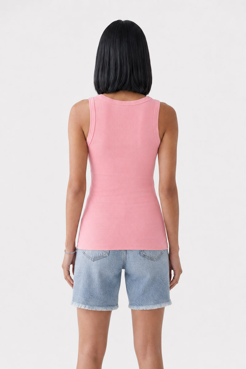 Eine Frau steht mit dem Rücken zur Kamera und präsentiert den Rücken eines ärmellosen, figurbetonten rosa Basic-Tops mit Rundhalsausschnitt von Princess Goes Hollywood, kombiniert mit knielangen blauen Jeansshorts mit ausgefransten Säumen. Das Top ist aus weicher Baumwolle gefertigt. Sie hat glattes, schulterlanges schwarzes Haar und steht vor einem schlichten hellgrauen Hintergrund.