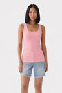 Eine Person mit glattem schwarzem Haar trägt ein pinkfarbenes, ärmelloses Basic-Top aus Baumwolle mit Rundhalsausschnitt von Princess Goes Hollywood sowie hellblaue Jeansshorts, steht frontal vor einem schlichten weißen Hintergrund und hält die Arme entspannt seitlich.