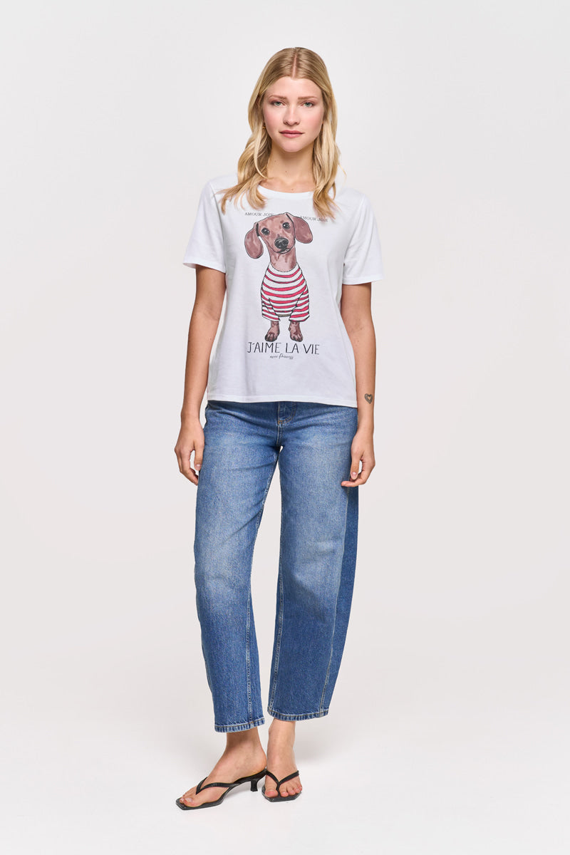 Eine blonde Frau trägt ein Princess Goes Hollywood T-Shirt aus Baumwolle mit Dackelaufdruck, Streifenmuster und "J'AIME LA VIE"-Schriftzug, gepaart mit blauen Jeans und schwarzen Sandalen vor einem schlichten, hellen Hintergrund.
