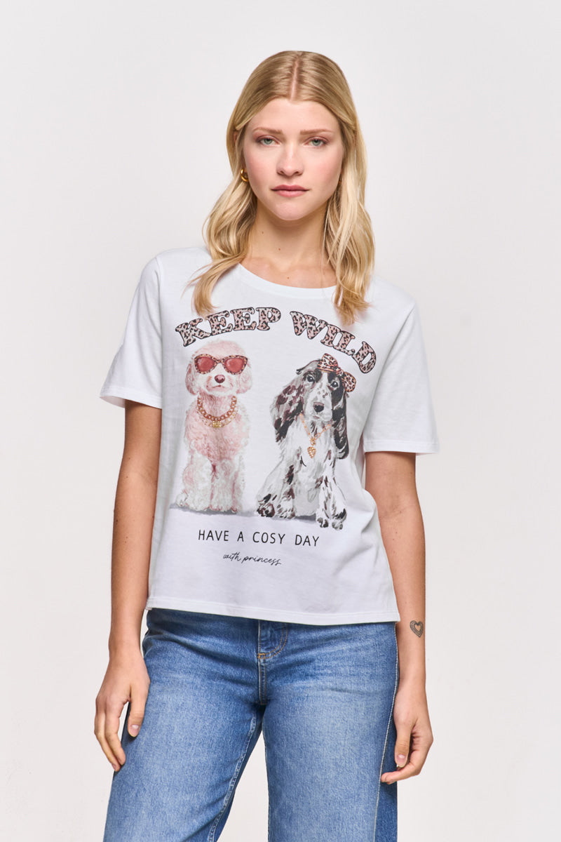 Eine Frau mit glattem blondem Haar trägt ein hellgraues Princess Goes Hollywood-T-Shirt mit einem Hunde-Print von zwei Hunden - einer mit Sonnenbrille, einer mit Schleife - und "KEEP WILD" darüber und "HAVE A COSY DAY" darunter. Dazu trägt sie eine blaue Jeans.