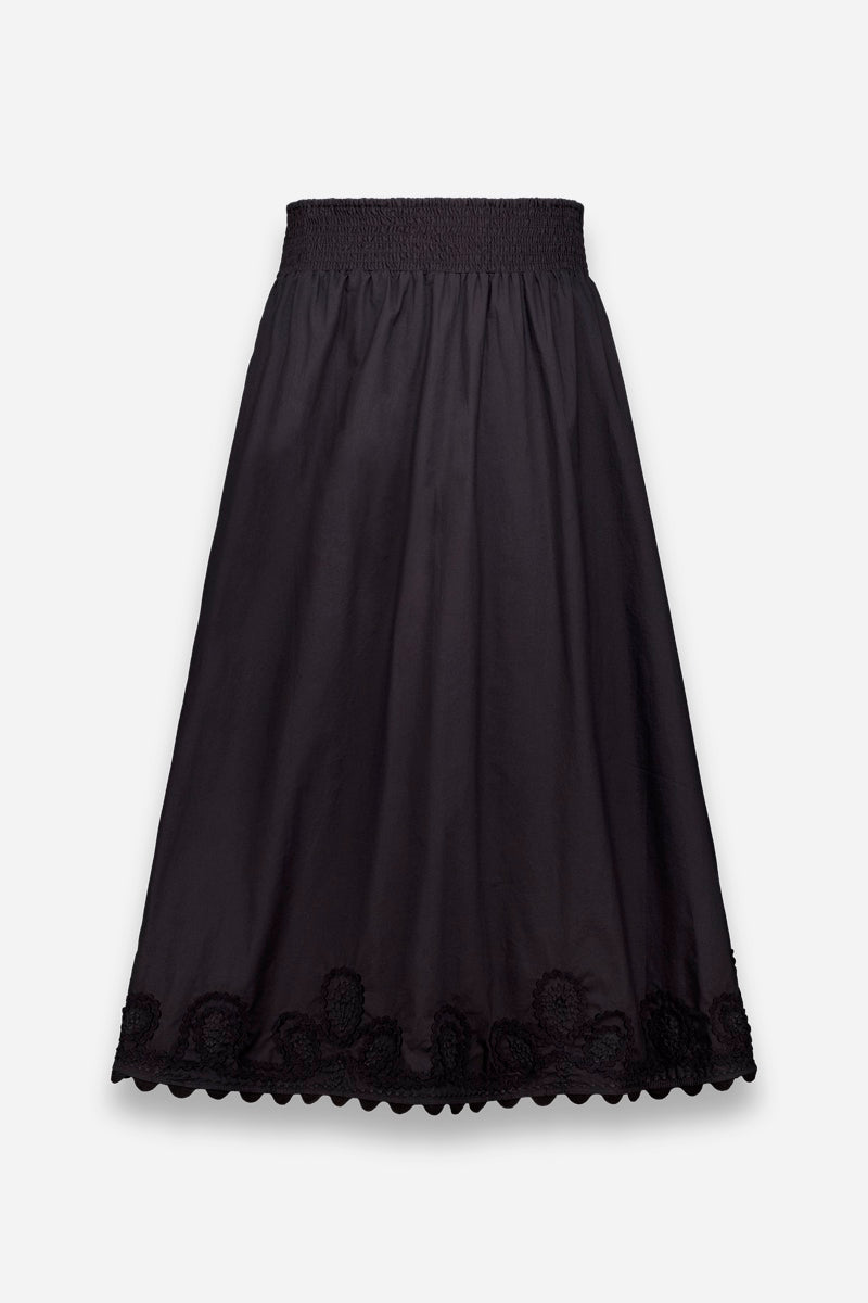 Der Princess Goes Hollywood Midirock aus schwarzer Baumwolle hat einen gesmokten, elastischen Bund, eine leicht ausgestellte Silhouette und eine überschnittene Stickerei mit floralen Spitzendetails am Saum. Abgebildet auf einem einfarbig weißen Hintergrund.