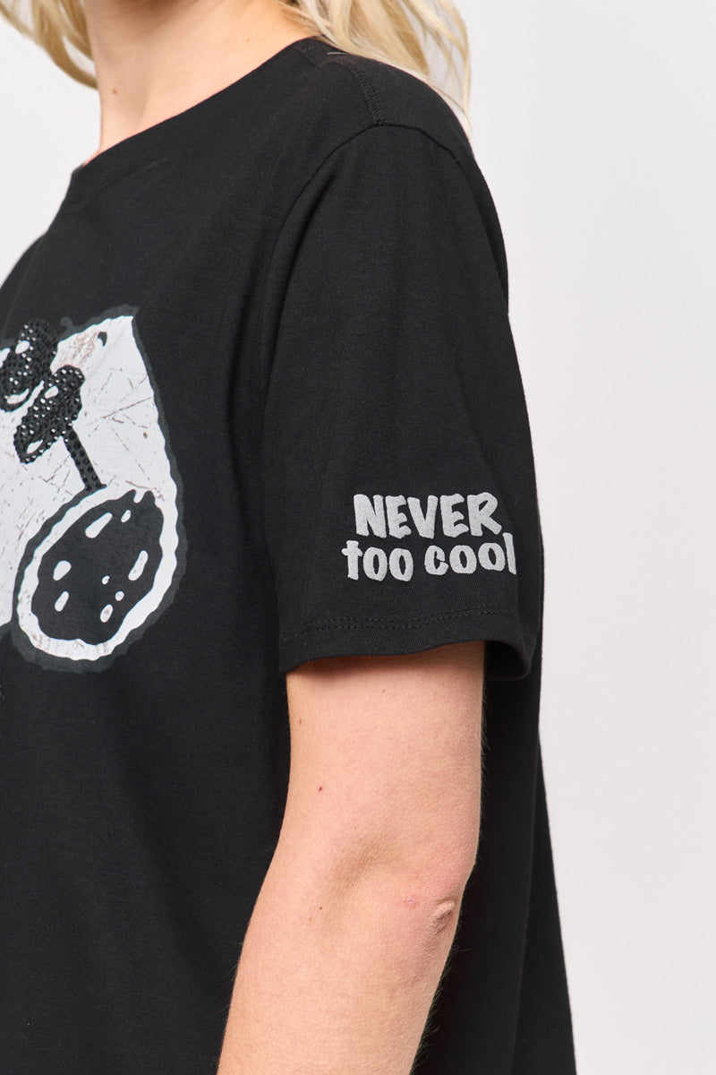 Eine Person mit blonden Haaren trägt ein schwarzes Princess Goes Hollywood T-Shirt von Baumwolle mit einer weißen Brustgrafik und dem fetten weißen Schriftzug "NEVER TOO COOL" auf dem Ärmel. Nur ihr Oberkörper und ein Teil ihres Kopfes sind sichtbar.