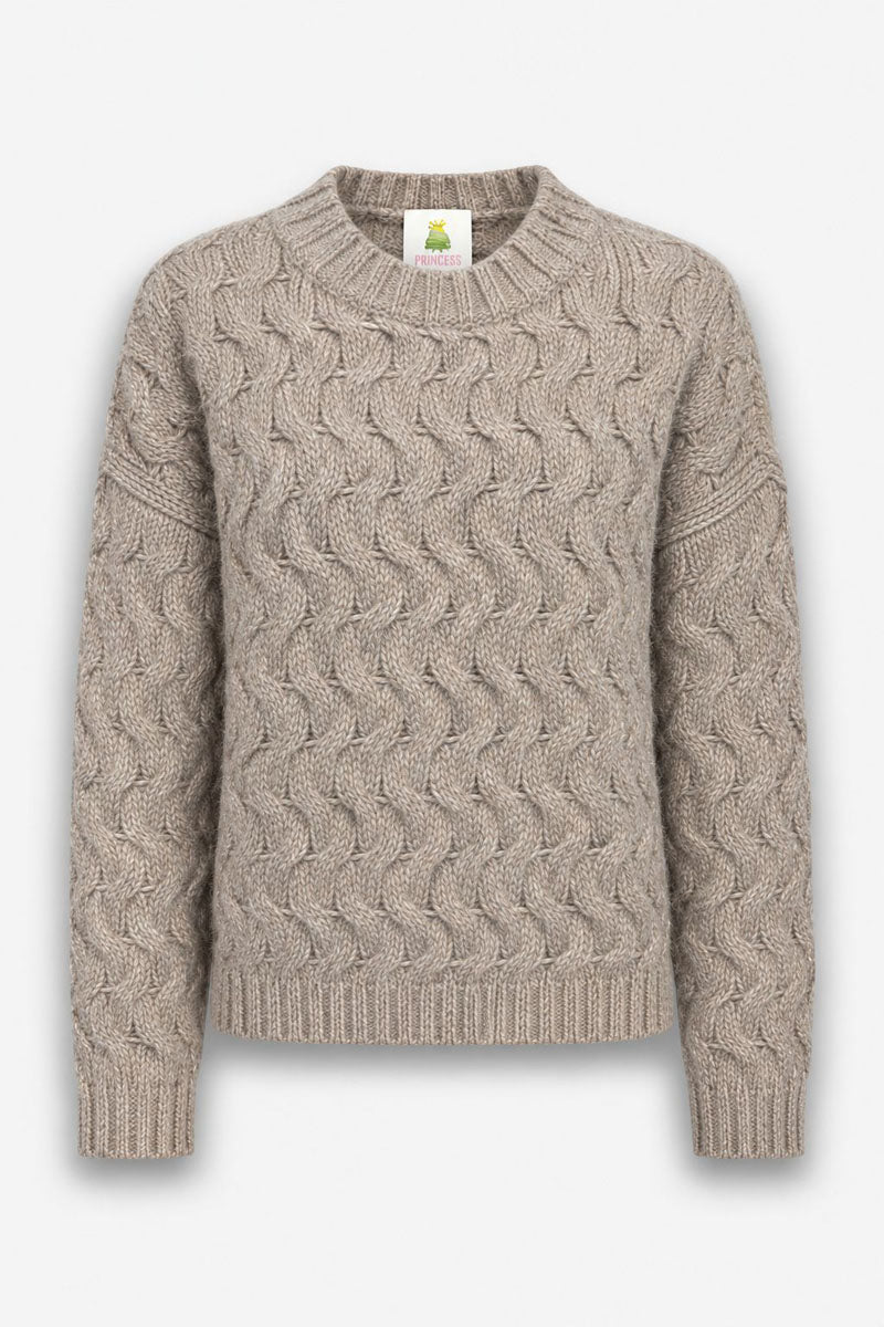 Ein beiger, langärmeliger Pullover mit Zopfmuster, der sich durch ein strukturiertes, wellenförmiges Zopfmuster auszeichnet. Er verfügt über gerippte Bündchen an Kragen, Ärmelenden und Saum sowie ein kleines Innenetikett mit der Aufschrift Princess und einer Kronengrafik.