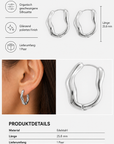 Abgebildet ist ein Paar wellenförmige, polierte silberfarbene Edelstahl-Creolen von Princess Goes Hollywood. In den Produktsymbolen und technischen Daten wird das Material als Edelstahl, die Länge als 25,8 mm und die Farbe als Silber angegeben; außerdem wird darauf hingewiesen, dass ein Paar im Lieferumfang enthalten ist. Diese skulpturalen Ohrringe werden zur Veranschaulichung der Größe auch am Ohr einer Person präsentiert.