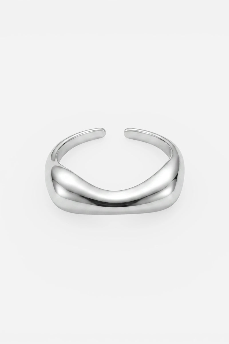 Ein minimalistisches, poliertes Armreif aus 925er Sterlingsilber von Princess Goes Hollywood besticht durch ein glattes, sanft geschwungenes Design und wird vor einem schlichten weißen Hintergrund präsentiert. Der Armreif ohne Verschluss sorgt für einen eleganten, modernen Look ohne sichtbare Verschlüsse oder Verzierungen – perfekt für Liebhaber von minimalistischem Schmuck.
