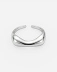 Ein minimalistisches, poliertes Armreif aus 925er Sterlingsilber von Princess Goes Hollywood besticht durch ein glattes, sanft geschwungenes Design und wird vor einem schlichten weißen Hintergrund präsentiert. Der Armreif ohne Verschluss sorgt für einen eleganten, modernen Look ohne sichtbare Verschlüsse oder Verzierungen – perfekt für Liebhaber von minimalistischem Schmuck.