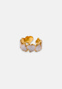 The Ring mit Herzen in Perlmutt-Optik by Princess Goes Hollywood features an open gold band with heart-shaped accents and pink and white Perlmutt-Optik, creating a romantic, elegant look against a plain background.