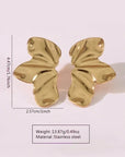 A pair of Princess Goes Hollywood Ohrstecker Edelstahl with a glänzende Oberfläche and abstraktem Schmetterlingsflügel-Design is shown on a pale background. Size: 4.47cm x 2.57cm; weight: 13.87g; made from stainless steel.