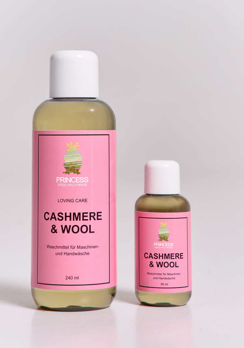 Zwei Princess Goes Hollywood-Flaschen - 240 ml und 50 ml - mit rosa Etiketten und grüner Krone stehen nebeneinander. Sie sind ideal als Kaschmir-Shampoo oder -Waschmittel geeignet, um Ihre empfindlichen Strickwaren zu pflegen.