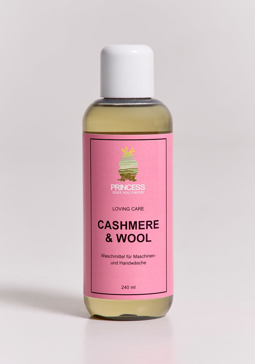 A clear plastic bottle with a white cap holds yellow liquid. Its pink label reads Princess Goes Hollywood, Loving Care Cashmere Waschmittel & Wollpflege for machine or hand wash, 240 ml.