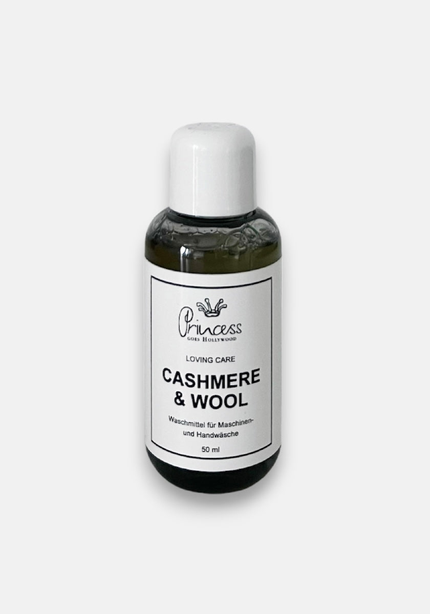 A small 50 ml clear bottle with a white cap, labeled “Princess Cashmere & Wool” in black text. The label also says Loving Care and notes it’s for machine and hand washing. The bottle contains greenish liquid and is set against a plain white background.
