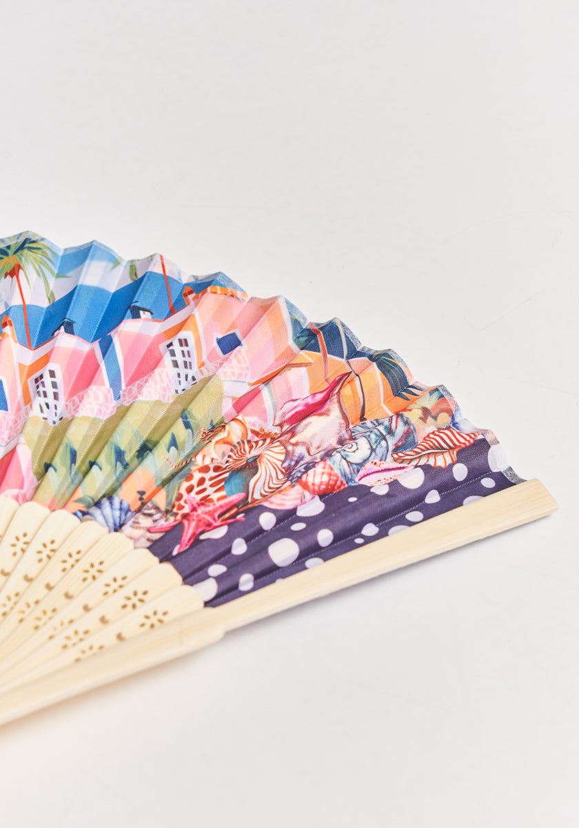 The Handfächer Miami by Princess Goes Hollywood boasts a wooden base and vibrant fabric with pink and blue buildings, palm trees, tropical animals, plus a chic dark section with white polka dots for a stylish statement.