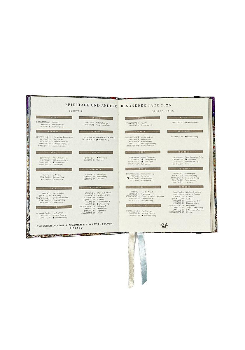 An open Princess Goes Hollywood Jahresplaner 2026 displays a holiday and special day table for Switzerland and Germany in German. Two ribbon bookmarks rest on a white background, with a colorful border outlining the planner’s cover edges.