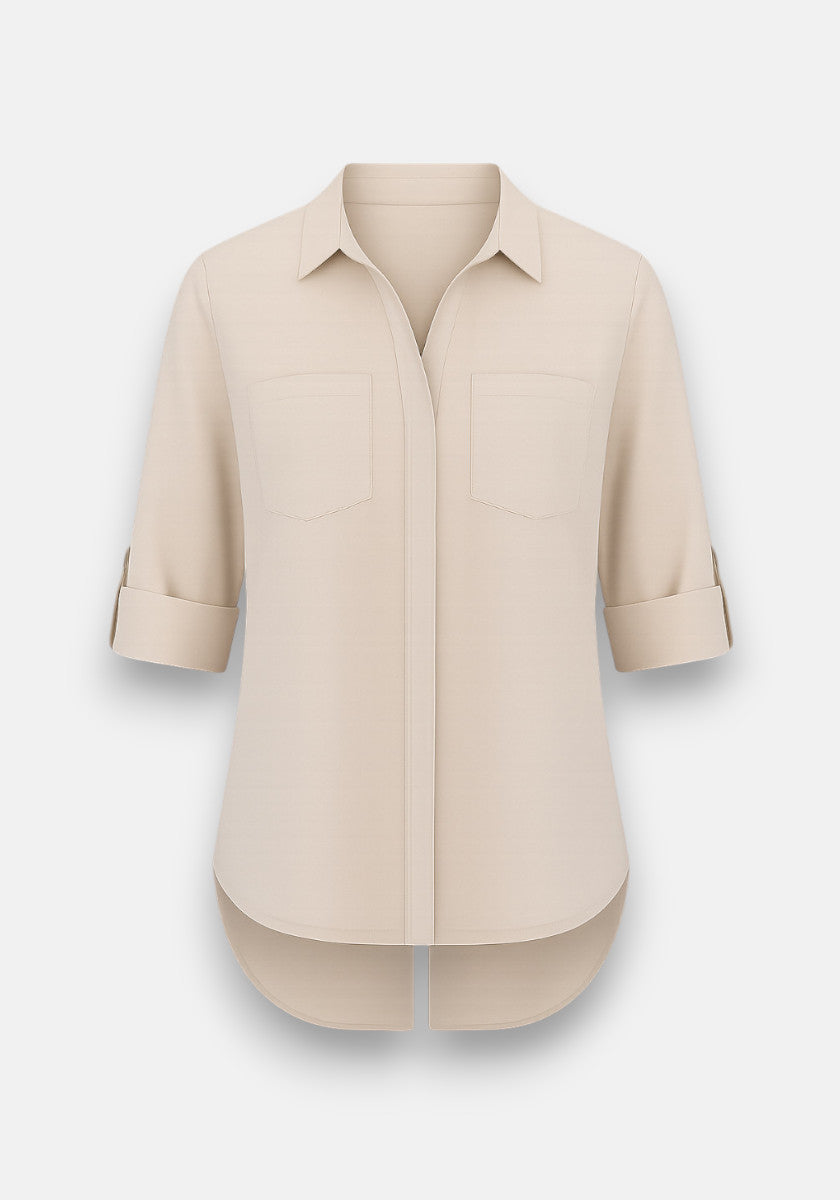 The Bella Dahl beige long-sleeve button-up blouse in soft Lyocell features a Hemdkragen, two chest pockets, rolled-up sleeves, and a gracefully curved high-low hem. The shirt looks neatly pressed against a plain white background.