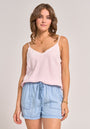 A woman with wavy brown hair wears a Bella Dahl light pink Trägertop with lace trim and light blue Lyocell shorts in Denimoptik. She stands relaxed, facing forward, accessorized with gold jewelry against a plain, light background.