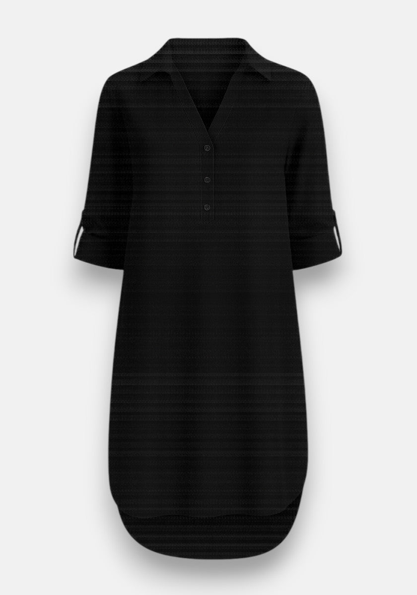 A black, knee-length Lyocell dress by Bella Dahl features a collar, V-neckline, three front buttons, long sleeves with buttoned tabs, and a slightly rounded hi-low hem. Shown against a plain light gray background.
