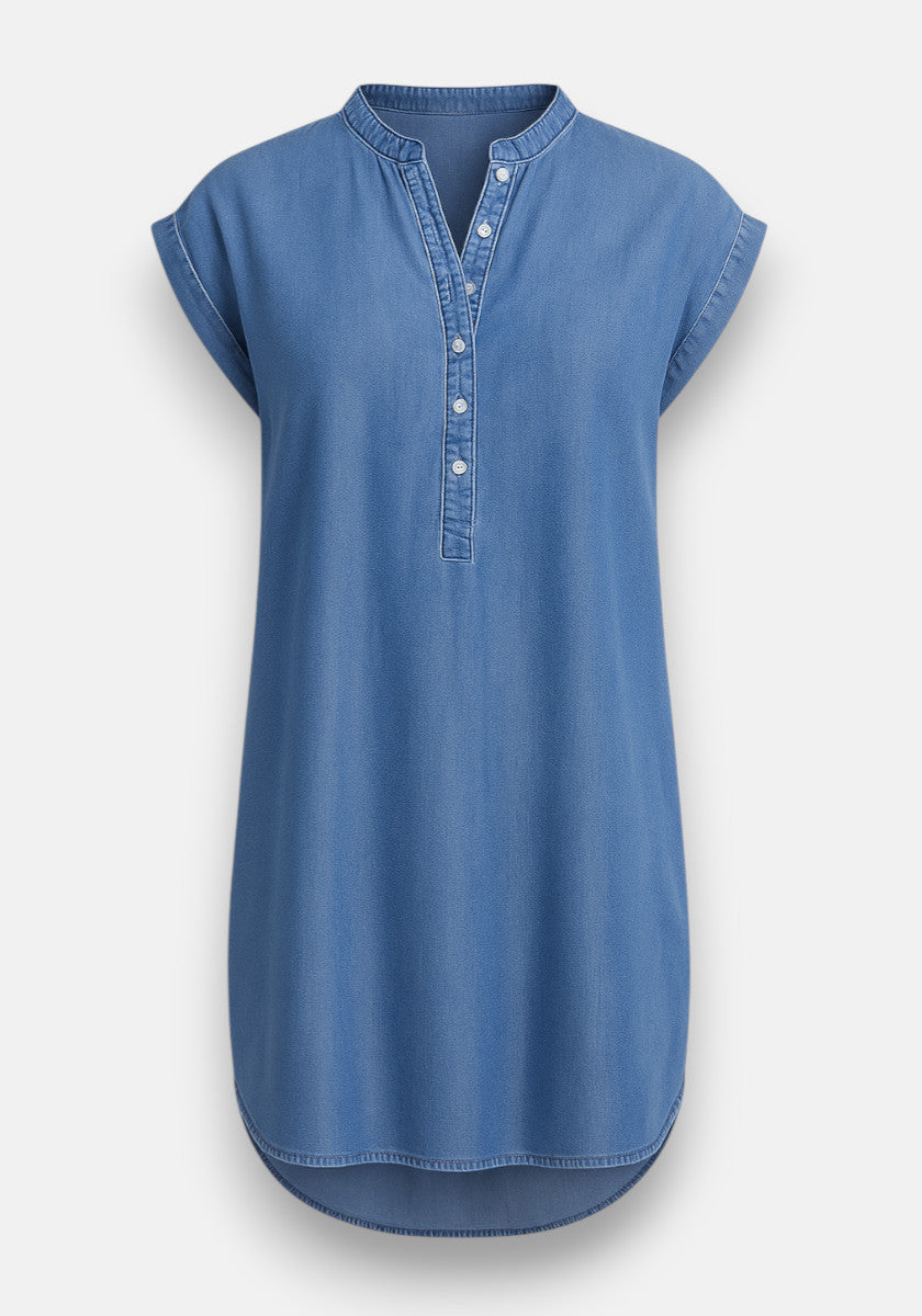 A blue Bella Dahl denim tunic dress with short, cuffed sleeves, a round band collar, and half-button placket. Made from Lyocell for a relaxed fit with a curved hem, this kurzes Kleid is shown against a plain white background.