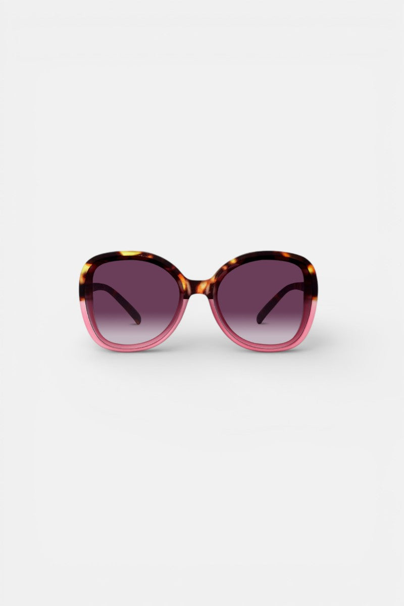 Okkia Oversized Sonnenbrille mit trendigem Butterfly-Design und braun-amberfarbenem Schildpattgestell, das zu Pink verblasst. Große, abgerundete Quadratgläser mit UV-400-Schutz und dunklem Verlaufstönung auf weißem Hintergrund.