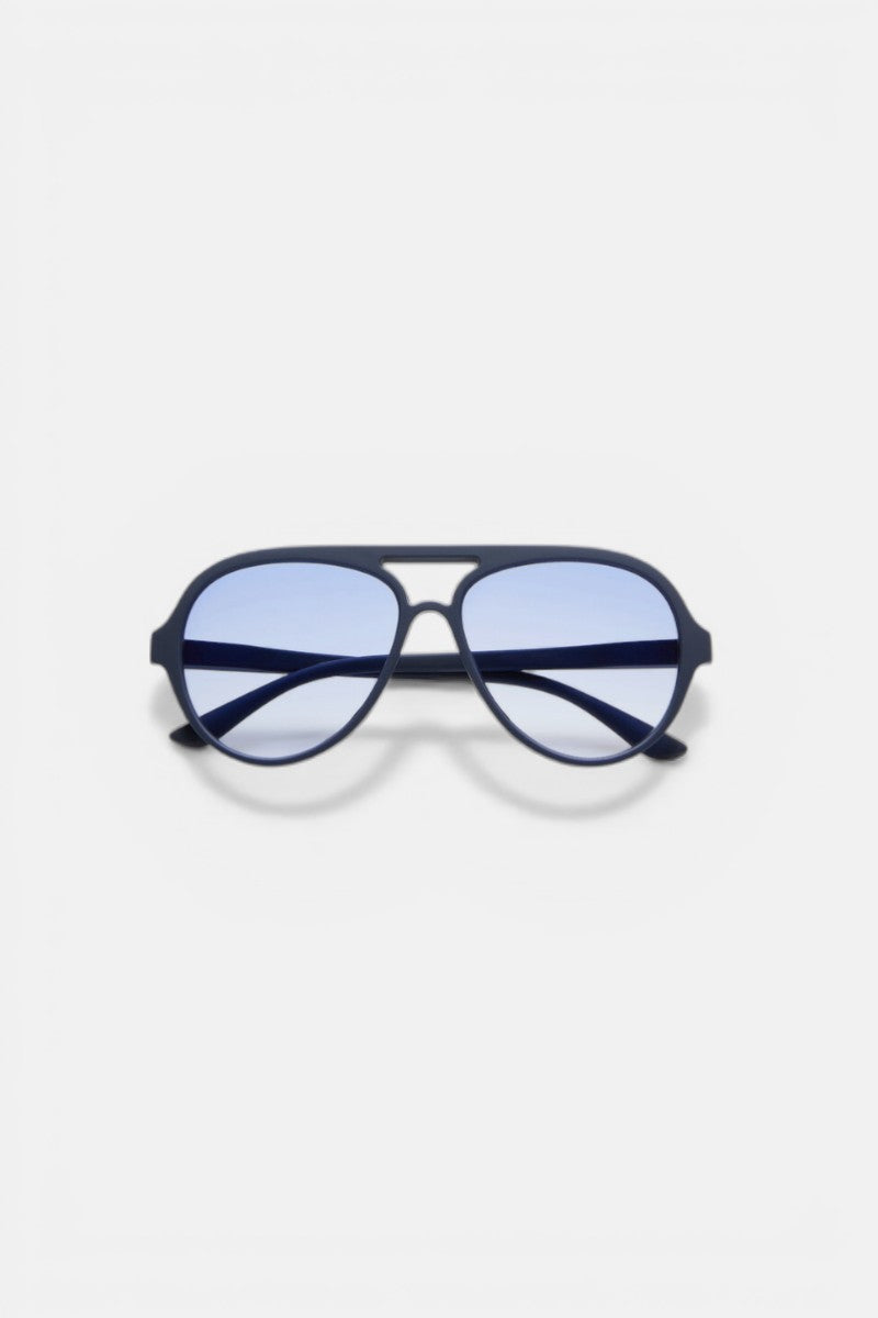 Eine Okkia Aviator Sonnenbrille mit dunkelblauem Rahmen, hellblau getönten Gläsern, UV 400 Schutz, Doppelbrücke und schwarzen Bügeln. Diese Unisex-Sonnenbrille bietet einen modernen Look vor einem schlichten weißen Hintergrund.