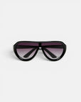 Eine schwarze Oversize-Pilotenbrille von Okkia wird auf weißem Hintergrund nach vorne gerichtet präsentiert. Sie zeichnet sich durch einen breiten Rahmen und dunkle Verlaufsgläser aus. Die Bügel der Sonnenbrille sind nach innen geklappt, was ihr ein modernes und markantes Design mit minimalistischem Charme verleiht. Diese PANAREA-Sonnenbrille verfügt über polarisierte Gläser von Okkia, die für verbesserte Sichtklarheit und Schutz sorgen.