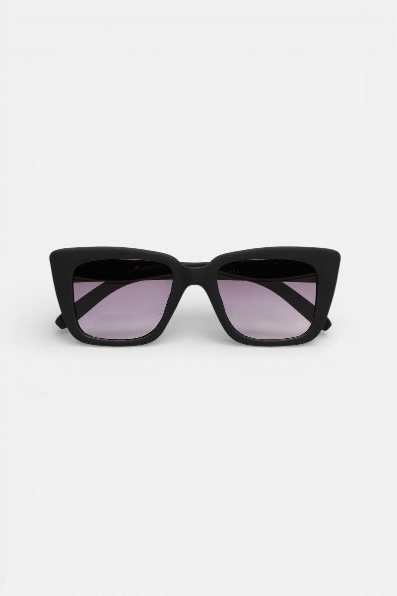 Eine schwarze, rechteckige Okkia-Sonnenbrille mit dickem Rahmen und leicht violett getönten Gläsern im Oversize-Design, mit UV-400-Schutz, vor einem schlichten weißen Hintergrund, direkt nach vorne gerichtet.