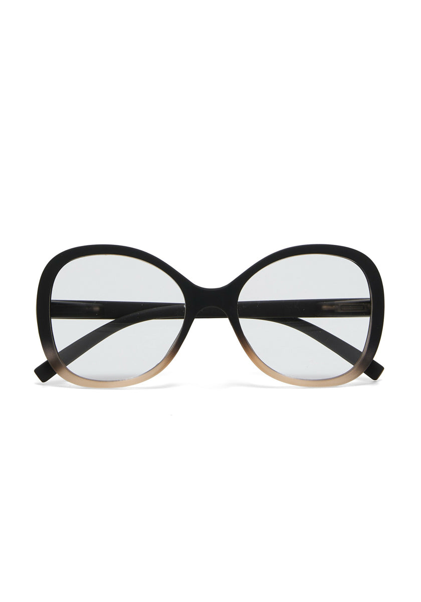 A pair of oversized, oval-shaped Okkia Lesebrille eyeglasses with thick black frames fading to light brown, soft-touch finish, clear lenses, and slightly curving black arms, shown on a plain white background.