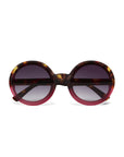 Okkia round sunglasses with oversized frames feature a tortoiseshell pattern on the top and outer edges, blending into translucent red at the bottom. The dark gradient lenses fade from black to light gray.