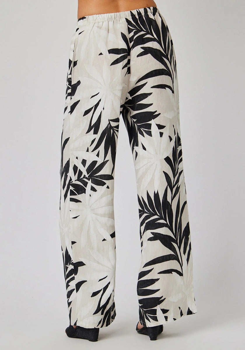 A person wears Bella Dahl Leinenhose with Palmen-Print, featuring wide legs, high waist, relaxed fit, and elastic waistband. Shown from the back against a plain background.