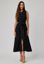 A woman with long wavy brown hair wears a sleeveless black Bella Dahl Lyocell midi dress with a tie belt and front slit. She stands facing forward in nude strappy sandals against a plain light gray background.
